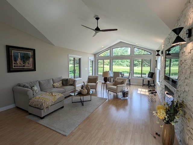5953 Qwinn Ct, Bay City, MI 48706 - living room with vaulted ceiling, a ceiling fan, wood finished floors, and a stone fireplace