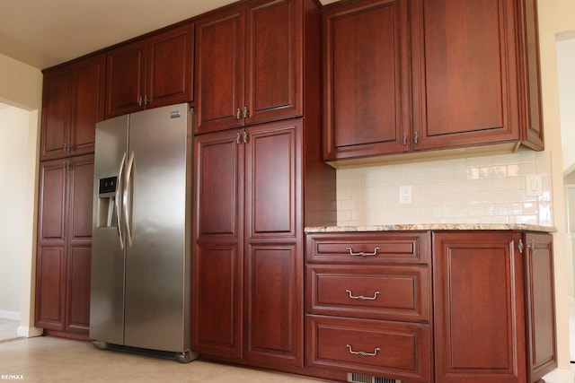 31717 Tecla St, Warren, MI 48088 - kitchen with stainless steel fridge, dark brown cabinets, tasteful backsplash, and light stone counters