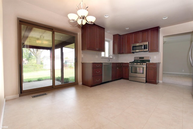 31717 Tecla St, Warren, MI 48088 - kitchen with stainless steel appliances, a chandelier, backsplash, recessed lighting, and light tile patterned floors