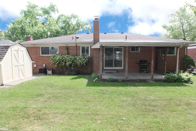 31717 Tecla St, Warren, MI 48088 - rear view of house with a chimney, a patio, a storage unit, brick siding, and a yard