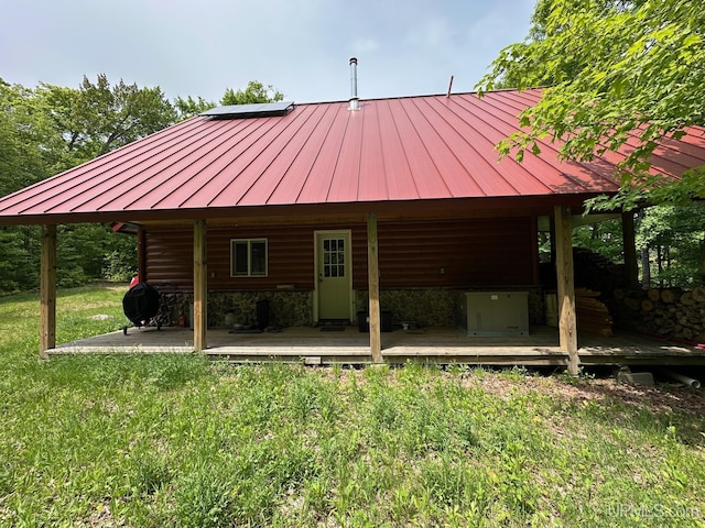 23505 Craig Lake Rd, Michigamme, MI 49861 - back of house featuring a standing seam roof, a metal roof, a lawn, and stone siding