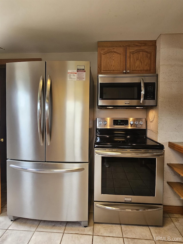 8199 Mill St, Ramsay, MI 49959 - kitchen with appliances with stainless steel finishes, brown cabinets, and light tile patterned flooring