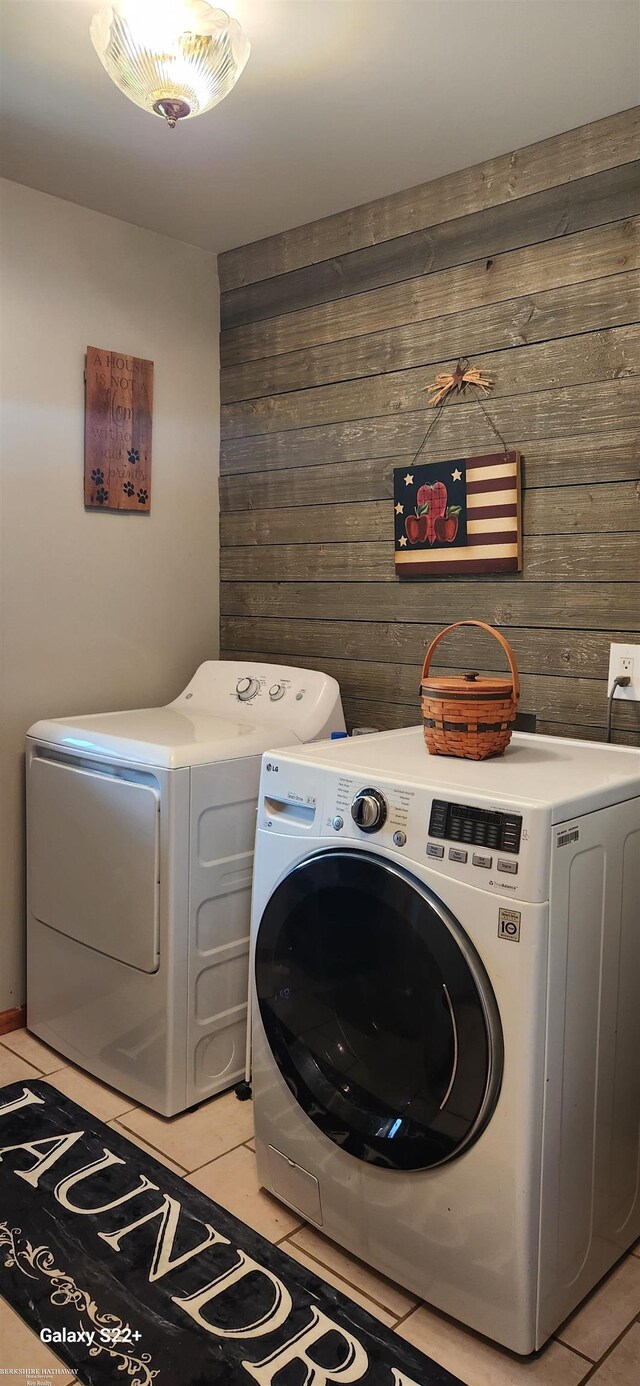 2793 Carina Dr, North Branch, MI 48461 - laundry area featuring wooden walls, washer and clothes dryer, and light tile patterned floors