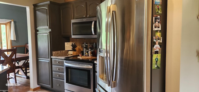 2793 Carina Dr, North Branch, MI 48461 - kitchen featuring stainless steel appliances, stone countertops, tasteful backsplash, and wood finished floors