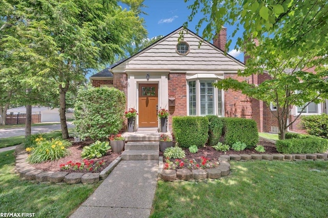 2080 Beaufait Dr, Grosse Pointe Woods, MI 48236 - view of front of house with a chimney, brick siding, and a front lawn