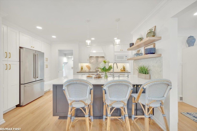 2080 Beaufait Dr, Grosse Pointe Woods, MI 48236 - kitchen featuring high quality fridge, white microwave, light countertops, light wood finished floors, and ornamental molding