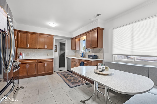 1389 Bedford Rd, Grosse Pointe Park, MI 48230 - kitchen with appliances with stainless steel finishes, tasteful backsplash, light countertops, crown molding, and brown cabinets