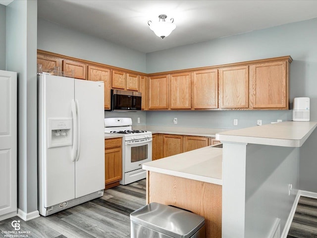 30569 Austin Ct, Chesterfield, MI 48051 - kitchen with white appliances, wood finished floors, light countertops, a peninsula, and a kitchen breakfast bar
