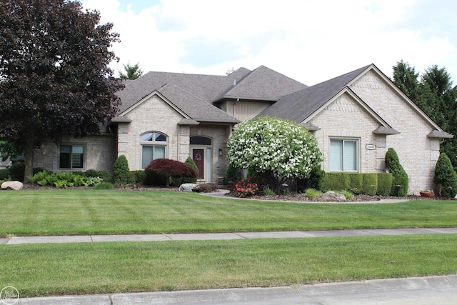 54640 Burlington Dr, Shelby Twp, MI 48315 - french country home with brick siding, a front yard, and roof with shingles