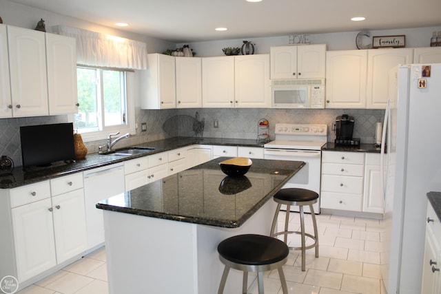 54640 Burlington Dr, Shelby Twp, MI 48315 - kitchen with white appliances, white cabinets, light tile patterned floors, a breakfast bar area, and dark stone counters