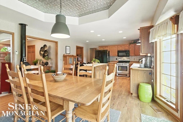 7119 Simons St, Lexington, MI 48450 - dining space featuring an ornate ceiling, light wood-type flooring, a wood stove, and recessed lighting