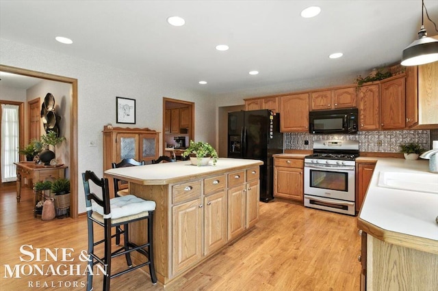 7119 Simons St, Lexington, MI 48450 - kitchen featuring black appliances, light countertops, light wood-style floors, tasteful backsplash, and recessed lighting
