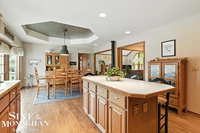 7119 Simons St, Lexington, MI 48450 - kitchen featuring a breakfast bar, light wood finished floors, a tray ceiling, plenty of natural light, and recessed lighting