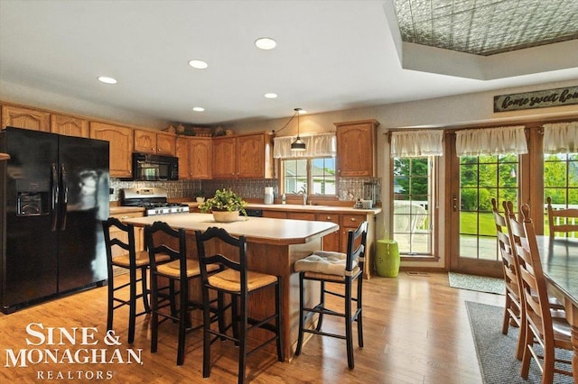 7119 Simons St, Lexington, MI 48450 - kitchen featuring black appliances, light countertops, tasteful backsplash, a center island, and recessed lighting