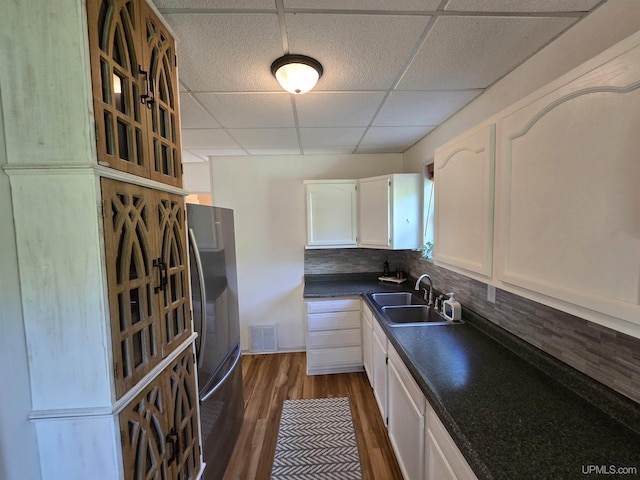 816 W Bluff St, Marquette, MI 49855 - kitchen featuring dark countertops, a paneled ceiling, white cabinets, freestanding refrigerator, and dark wood-style flooring