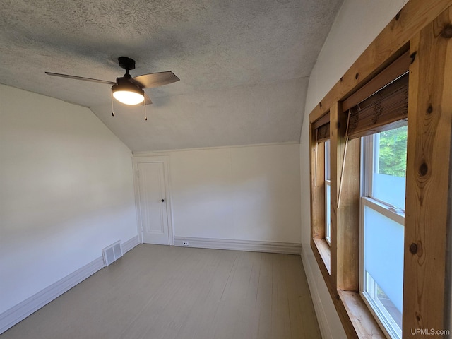 816 W Bluff St, Marquette, MI 49855 - spare room featuring a textured ceiling, lofted ceiling, ceiling fan, and wood finished floors