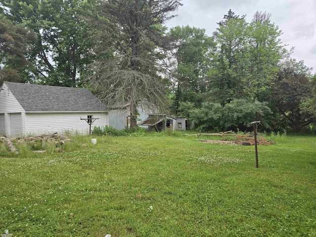 1675 Bauman Rd, Columbus, MI 48063 - view of green lawn with an outbuilding and a garage
