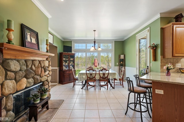 14329 Barton Dr, Washington Twp, MI 48094 - dining space with a wainscoted wall, ornamental molding, light tile patterned floors, a stone fireplace, and a decorative wall