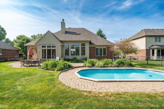14329 Barton Dr, Washington Twp, MI 48094 - back of house featuring a chimney, a patio area, brick siding, and board and batten siding