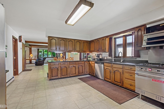 6499 Tubspring Rd, Almont, MI 48003 - kitchen featuring stainless steel appliances, a baseboard heating unit, brown cabinetry, dark countertops, and a peninsula