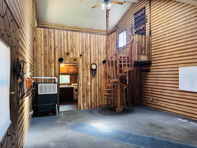 4110 Oak Ridge Dr, Harrison, MI 48625 - unfurnished living room featuring high vaulted ceiling, carpet floors, stairs, ceiling fan, and wooden walls
