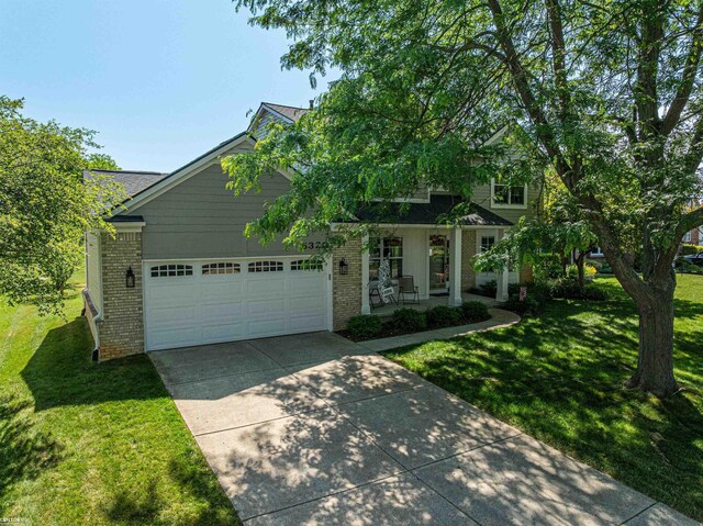 5320 Riverwalk Trl, Commerce Twp, MI 48382 - traditional home with brick siding, concrete driveway, covered porch, and a front lawn