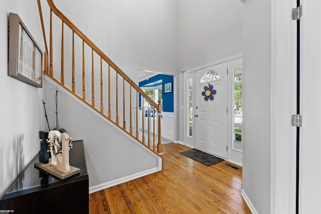 5320 Riverwalk Trl, Commerce Twp, MI 48382 - entryway with wood finished floors, stairway, healthy amount of natural light, and a towering ceiling