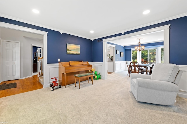 5320 Riverwalk Trl, Commerce Twp, MI 48382 - carpeted living room with crown molding, a chandelier, wainscoting, and recessed lighting