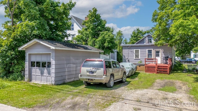 605 S 9th St, Escanaba, MI 49829 - view of front of house featuring an outdoor structure, a deck, and a front lawn