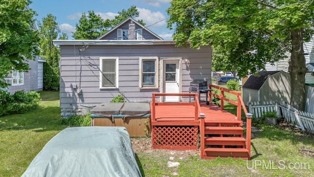 605 S 9th St, Escanaba, MI 49829 - rear view of property featuring a hot tub, a wooden deck, and a storage shed