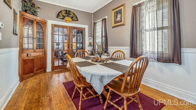 605 S 9th St, Escanaba, MI 49829 - dining area featuring wainscoting, french doors, hardwood / wood-style floors, and crown molding