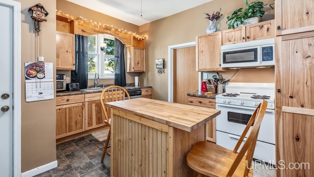 605 S 9th St, Escanaba, MI 49829 - kitchen featuring white appliances, wooden counters, light brown cabinets, a kitchen bar, and stone finish flooring