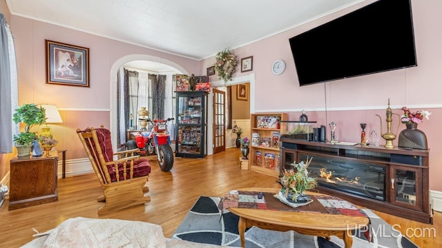 605 S 9th St, Escanaba, MI 49829 - living area featuring ornamental molding, wood finished floors, a wainscoted wall, and arched walkways