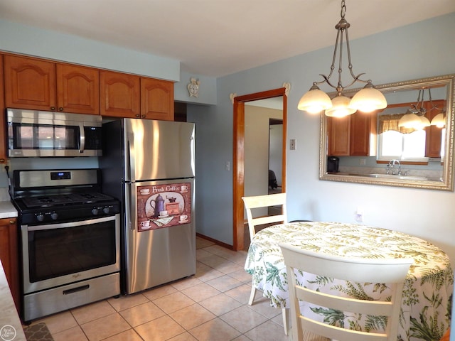8508 Darlene St, Warren, MI 48093 - kitchen featuring stainless steel appliances, light countertops, light tile patterned floors, brown cabinets, and a chandelier