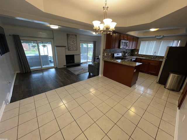 11485 Racine St, Warren, MI 48093 - kitchen with appliances with stainless steel finishes, a peninsula, open floor plan, a chandelier, and light tile patterned floors