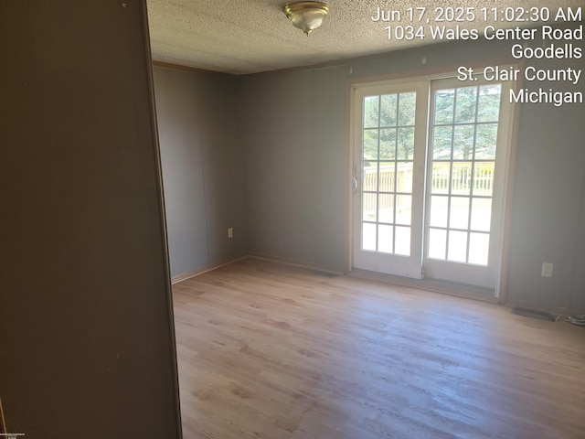 9310 Hill Rd, Wales, MI 48027 - spare room featuring light wood-type flooring and a textured ceiling