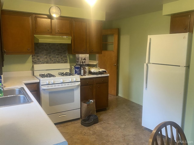 26121 S Calumet St, Laurium, MI 49913 - kitchen with white appliances, under cabinet range hood, tile patterned floors, light countertops, and brown cabinets