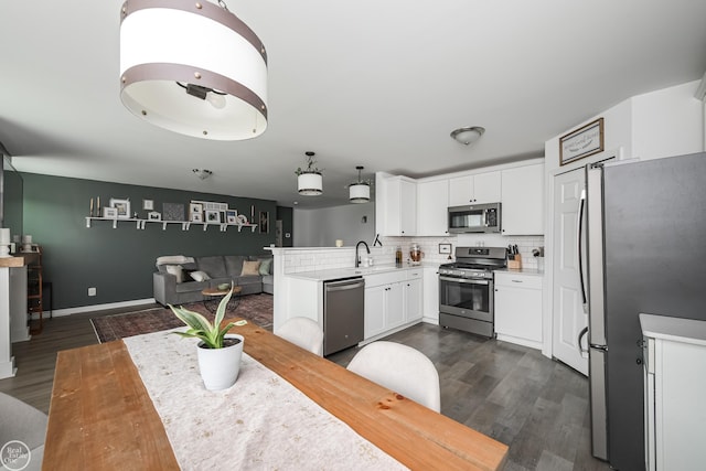 58530 Westmoore Cir, New Haven, MI 48048 - kitchen with appliances with stainless steel finishes, white cabinetry, dark wood-style floors, a peninsula, and decorative backsplash
