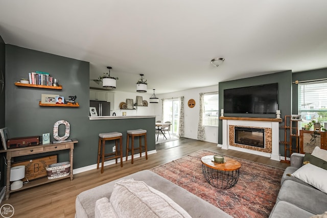 58530 Westmoore Cir, New Haven, MI 48048 - living area with plenty of natural light, wood finished floors, and a glass covered fireplace