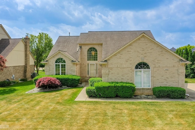 14060 Wayford Run, Shelby Twp, MI 48315 - view of front facade with brick siding, a shingled roof, and a front yard