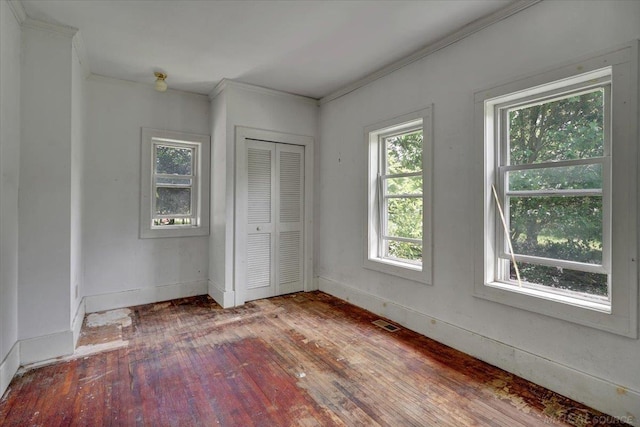 79050 Capac Rd, Armada, MI 48005 - unfurnished bedroom featuring crown molding, wood-type flooring, multiple windows, and a closet