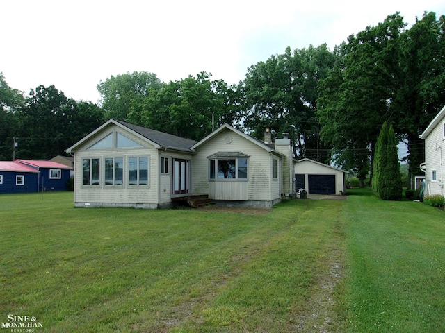 2221 N Channel Dr, Harsens Island, MI 48028 - back of property with entry steps, a garage, a lawn, crawl space, and a chimney
