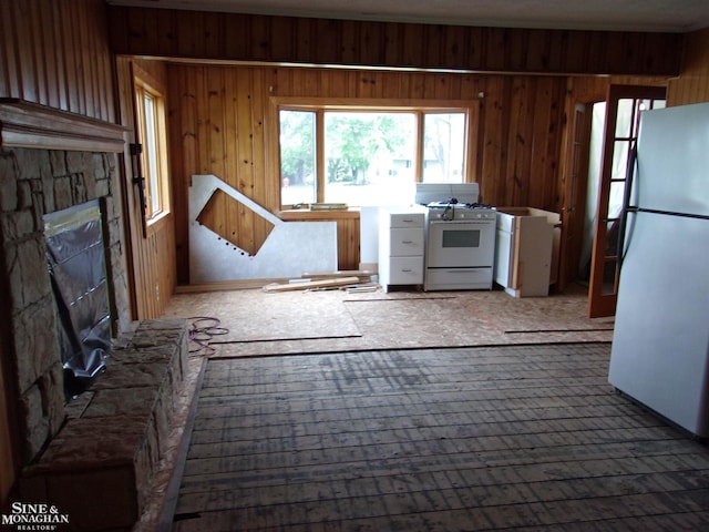 2221 N Channel Dr, Harsens Island, MI 48028 - kitchen with white appliances, wood walls, and a fireplace