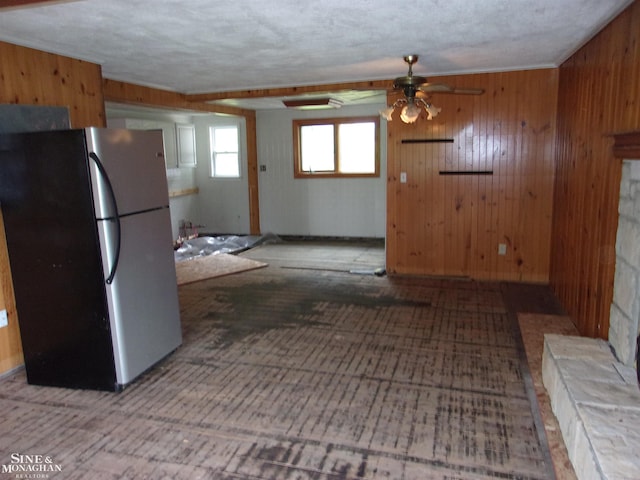 2221 N Channel Dr, Harsens Island, MI 48028 - kitchen with freestanding refrigerator, ceiling fan, and wood walls