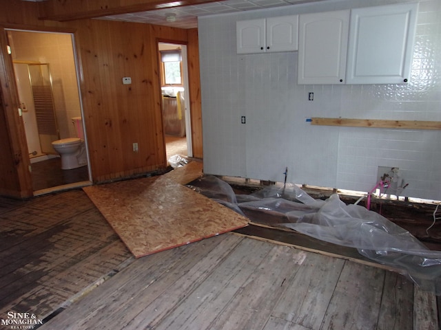 2221 N Channel Dr, Harsens Island, MI 48028 - kitchen with wood-type flooring, white cabinets, and wood walls