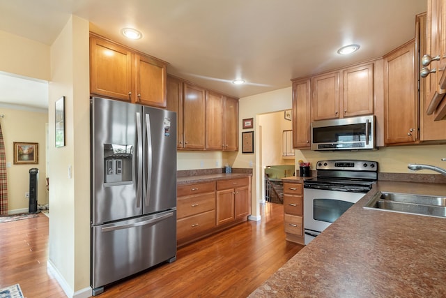 3667 Alderdale Dr, Sterling Heights, MI 48310 - kitchen featuring stainless steel appliances, dark wood-type flooring, dark countertops, recessed lighting, and ornamental molding