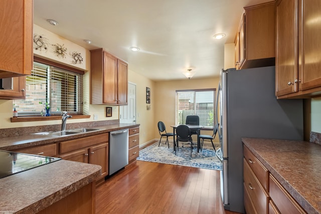 3667 Alderdale Dr, Sterling Heights, MI 48310 - kitchen with stainless steel appliances, dark countertops, dark wood-type flooring, brown cabinetry, and recessed lighting