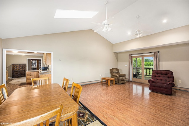 6920 Snover Rd, Decker, MI 48426 - dining space with a baseboard radiator, high vaulted ceiling, light wood-style flooring, ceiling fan, and a skylight