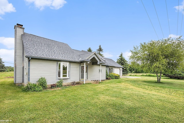6920 Snover Rd, Decker, MI 48426 - view of front of house with an attached garage, roof with shingles, a front lawn, a chimney, and concrete driveway