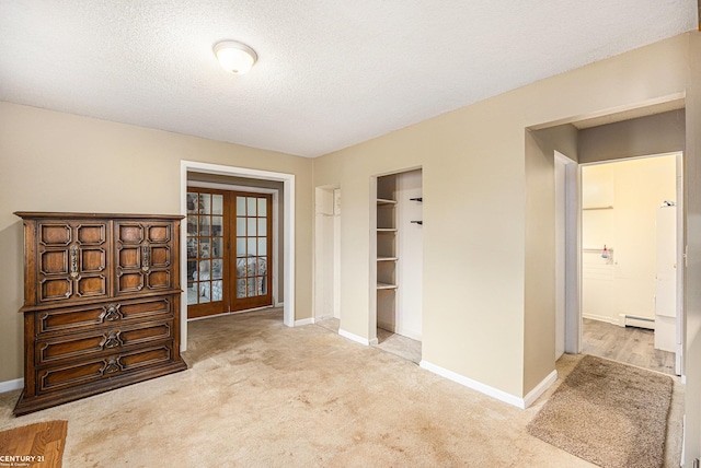 6920 Snover Rd, Decker, MI 48426 - bedroom featuring french doors, a baseboard heating unit, carpet flooring, a textured ceiling, and a closet